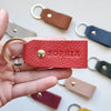 Close-up of brown leather keyring with initials, designed for her