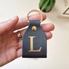 Accesorio de cuero con inicial grabada, ideal para regalo especial